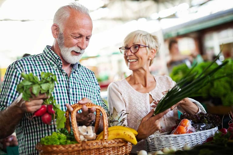 Older couple choosing fresh produce at a market