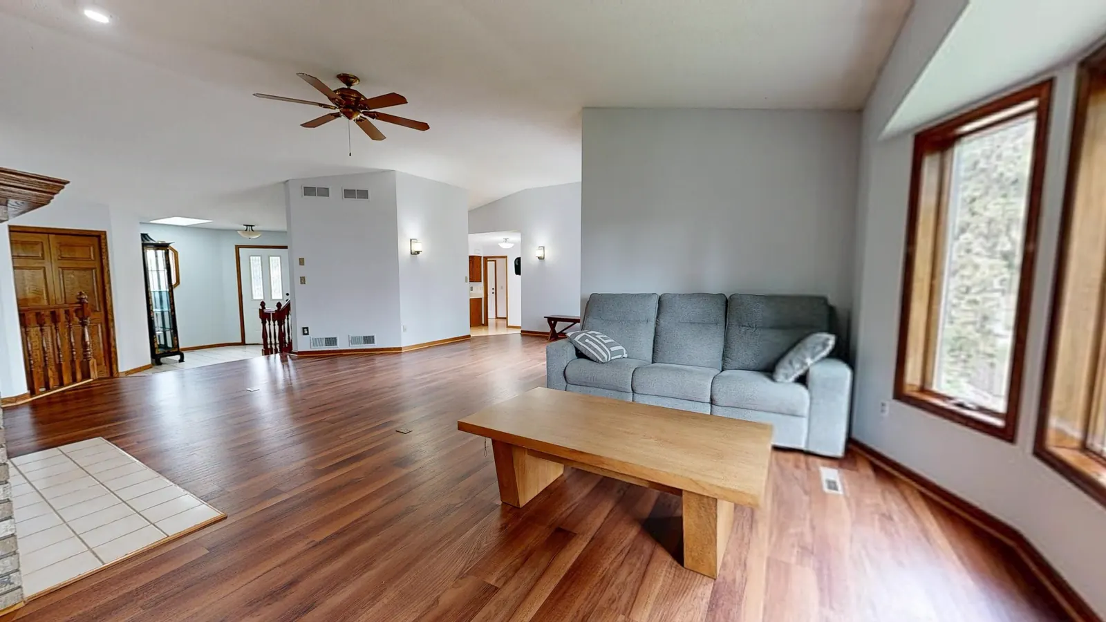Open-plan living room with seating and wood-look flooring