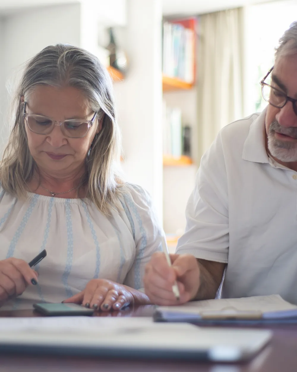Older couple organizing written information at a table
